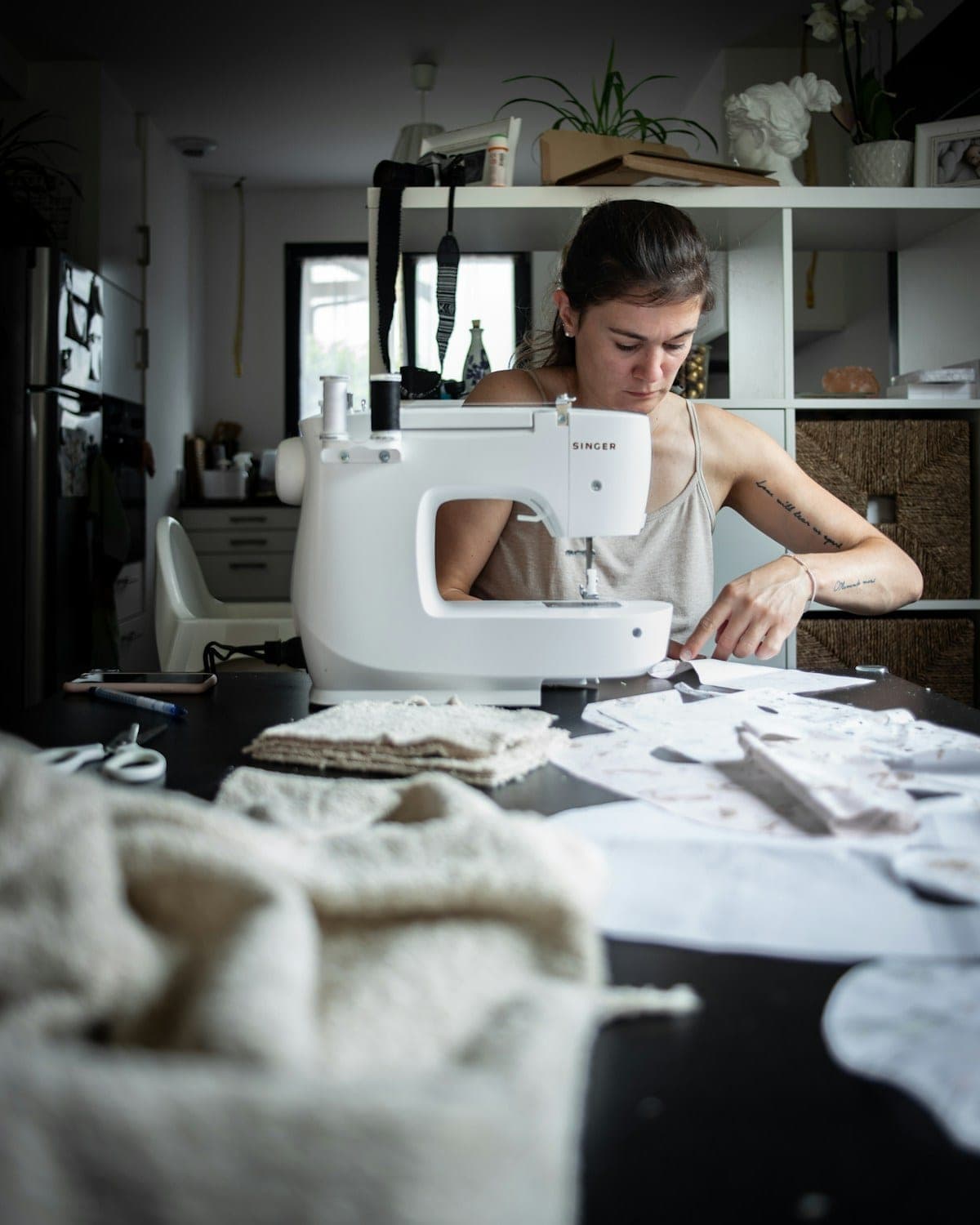 Designer sewing at the machine in the Deborah atelier